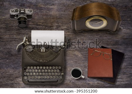 Vintage typewriter ,old clock and old camera on wood background
