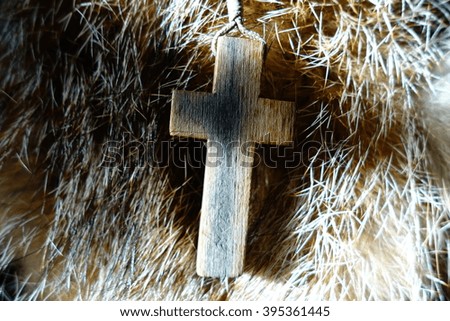 Wooden cross on a gold and brown fur