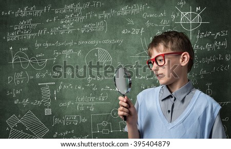 Curious school boy with magnifier