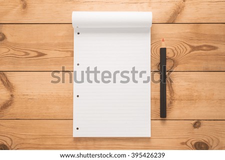 Notepad with pencil on a wooden desk 


