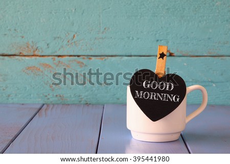 cup of coffee and little heart shape chalkboard with the phrase: GOOD MORNING.
