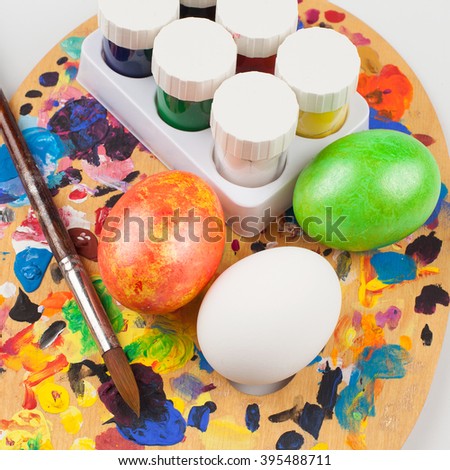 Easter. The creative approach. To paint eggs. Painted in different color eggs, paint, tassel, and one unpainted egg in the color palette