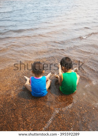 the two children are playing in summer near the river