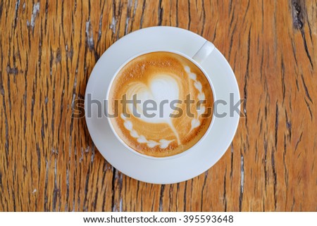 a selective foucus coffee picture on top view of a cup on blurred wooden floor of the table