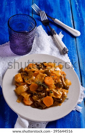 Vegetables with mushrooms stewed in a ceramic plate. Selective focus.