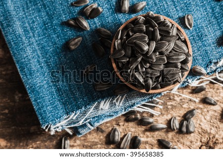 Fresh Sunflower seed and oil. Shelled sunflower seeds in wood bowl. 
Sunflower close-up