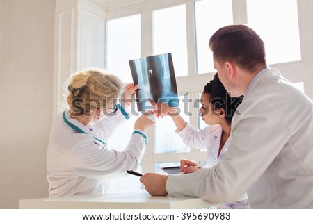Healthcare, medical: Group of multi-ethnic doctors discuss and looking x-ray in a clinic or hospital