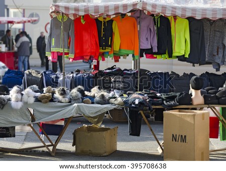stall with clothes and caps at a weekly market