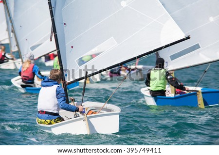 group of children on sailing boats competing in the regatta at sea