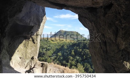 The Puy de Dome volcano seen from a hole in a rock Royalty-Free Stock Photo #395750434