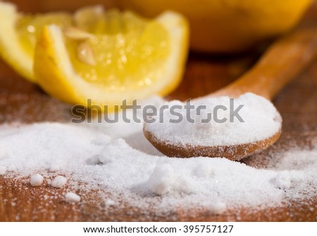 baking soda (sodium bicarbonate) in a wooden spoon and lemon Royalty-Free Stock Photo #395757127