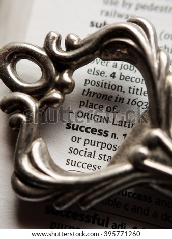 Conceptual image of the dictionary definition of success surrounded by the top half of a vintage key.