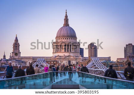 London, England - St.Paul's Cathedral and Millennium Bridge with Londoners walking through at sunset