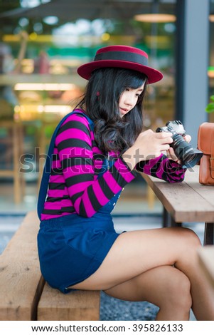 Lifestyle portrait of pretty young Photographer  woman having fun in coffee shop