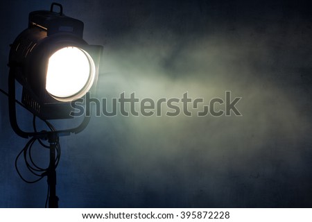 theater spot light with smoke against grunge wall Royalty-Free Stock Photo #395872228