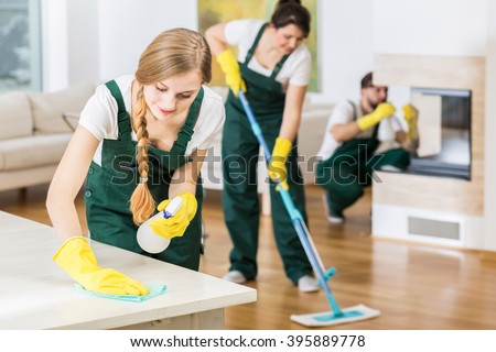 Group of friends as a professional cleaners tiding up big apartment Royalty-Free Stock Photo #395889778