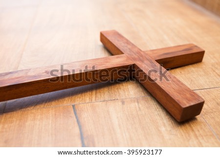 wooden cross on wooden background.