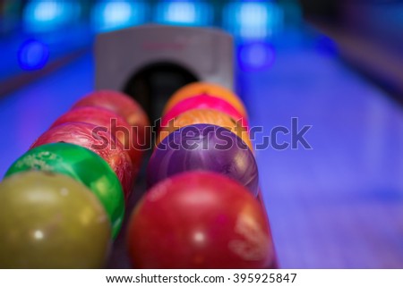 Close up of bowling balls with bowling lane in the background.