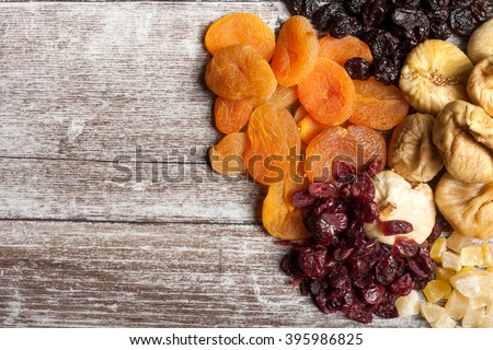 Mix of dried fruits and nuts on wooden background. Top view. Almonds, cashew and other healthy fruits. Organic and healthy Royalty-Free Stock Photo #395986825