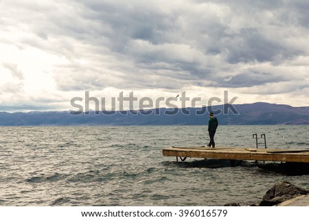 Man stands on dock in Ohrid, Macedonia