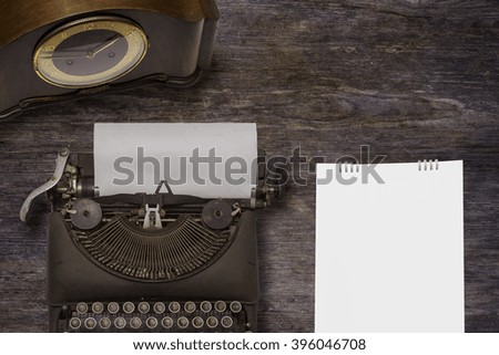 Vintage typewriter ,old clock on wood background
