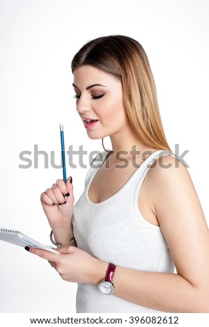 young student girl with notebook and pen planning her daily schedule wearing casual white t-shirt on white. Studio retouched shot