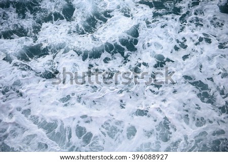 Background blue waves of the sea with sea foam  