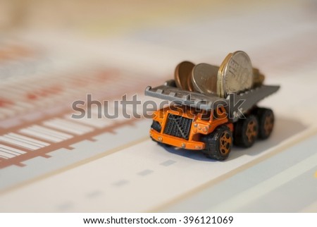 Toy truck full of coins - an abstract picture for financial news, bank loans, finance and money savings. Scholarship, fee, benefit, dividend stock photo, bitcoin stock image.