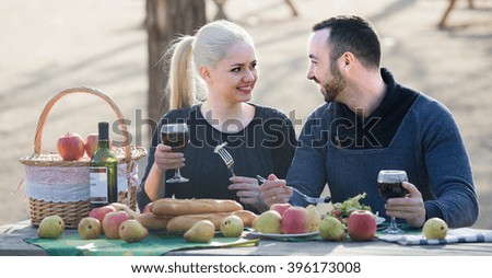 Portrait of young adults drinking wine at table in nature outdoor