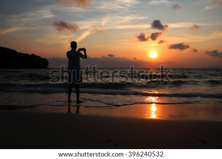 Men use the phone to take pictures of sunrise at ang thong beach.