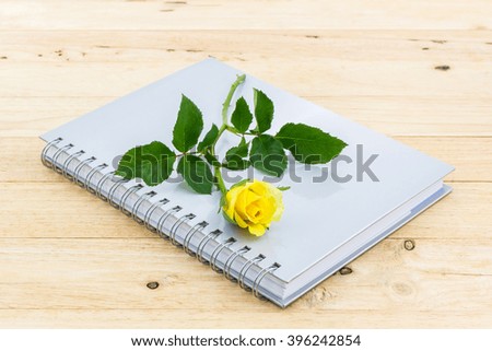 Beautiful yellow rose on the spiral notebook.