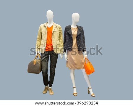 Two mannequins, male and female, dressed in casual clothes. Isolated on grey background Royalty-Free Stock Photo #396290254