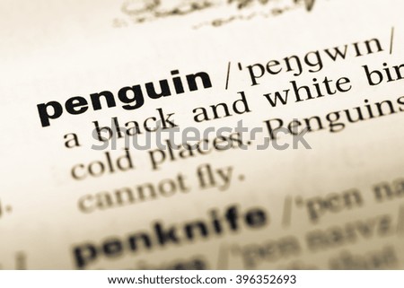 Close up of old English dictionary page with word penguin