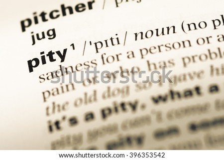 Close up of old English dictionary page with word pity