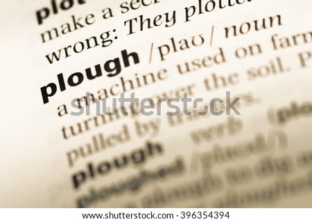 Close up of old English dictionary page with word plough
