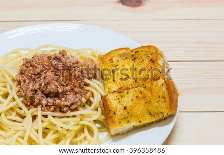 Spaghetti Bolognese with tomato pork sauce and garlic bread  in a dish.