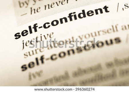 Close up of old English dictionary page with word self confident