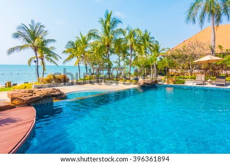 Beautiful luxury Swimming pool with palm tree and sea background in hotel pool resort - Boost up color Processing