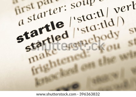 Close up of old English dictionary page with word startle