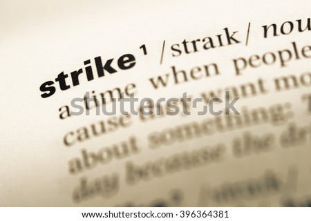 Close up of old English dictionary page with word strike