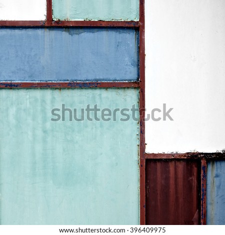 Geometric sheet metal door background with green, blue and red colors, front view.