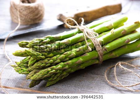 Bunch of fresh asparagus on wooden table Royalty-Free Stock Photo #396442531