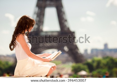 Beautiful woman reading book in Paris background the Eiffel tower 
