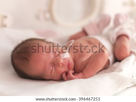 Premature newborn  baby girl in the hospital incubator after c-section in 33 week Royalty-Free Stock Photo #396467251