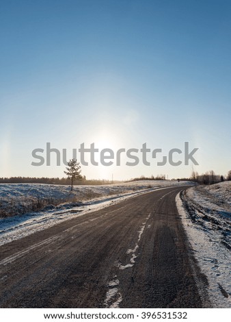 empty road in the countryside with trees in surrounding. perspective in winter
