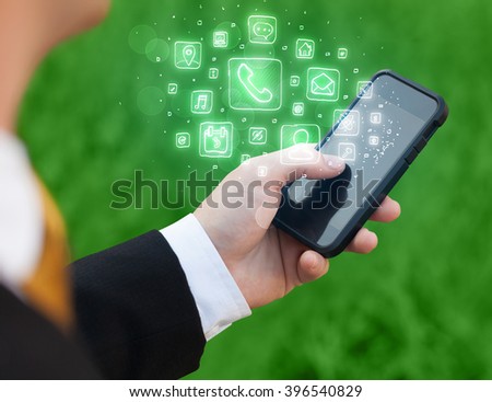 Hand holding smartphone with glowing mobile app icons