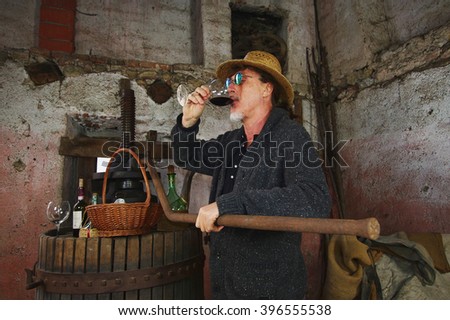 Mature winemaker testing wine in old winery