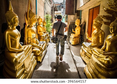 Man was walking through golden buddha road.Bangkok Thailand. Royalty-Free Stock Photo #396564157