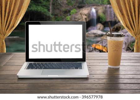 laptop computer and coffee cup on table  seat overlooking water fall
