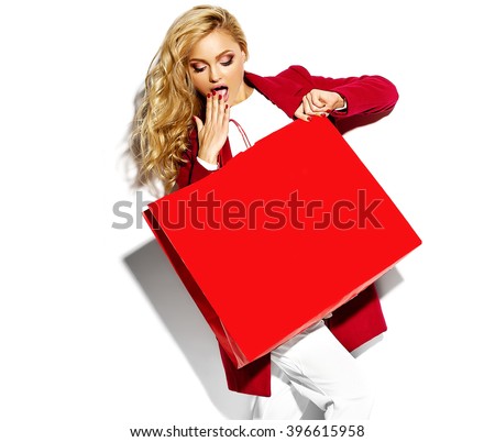 portrait of beautiful cute happy sweet surprised blonde woman girl holding in her hands big shopping bag in hipster red clothes isolated on white Royalty-Free Stock Photo #396615958